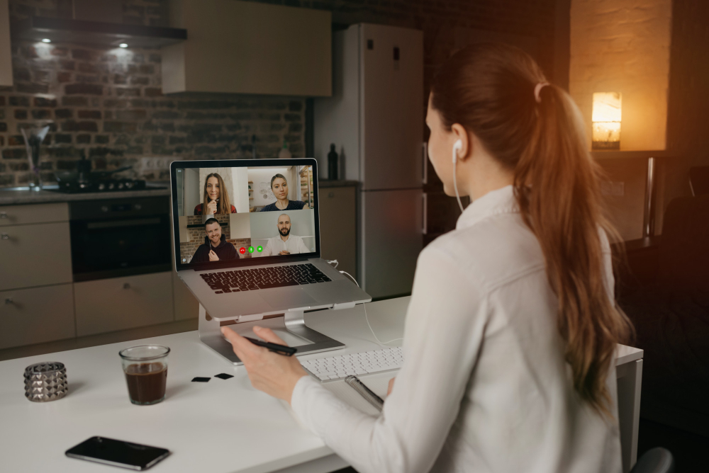 back-view-female-employee-working-remotely-talking-her-colleagues-about-business-video-conference-desktop-computer-home-multiethnic-business-team-online-meeting